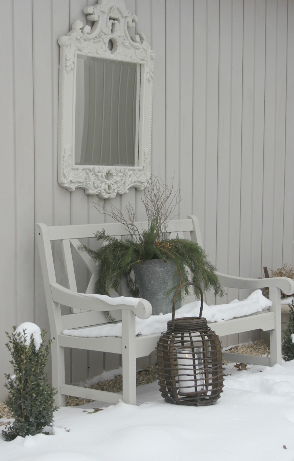 Serene white bench and mirror with winter holiday decor - Hello Lovely Studio. Come be calmed by How to Freak Less About Holidays, Decorating and Gifts as well as Entertaining.