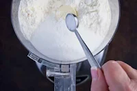 Measuring dry ingredients into food processor to make shortbread crust for pecan pie bars