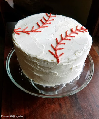 tall round cake decorated like a baseball