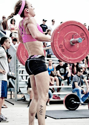 Image of a woman performing an Olympic powerlifting Clean during a CrossFit competition