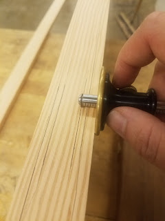 Using a marking gauge to scribe a half inch offset from the sides of the board
