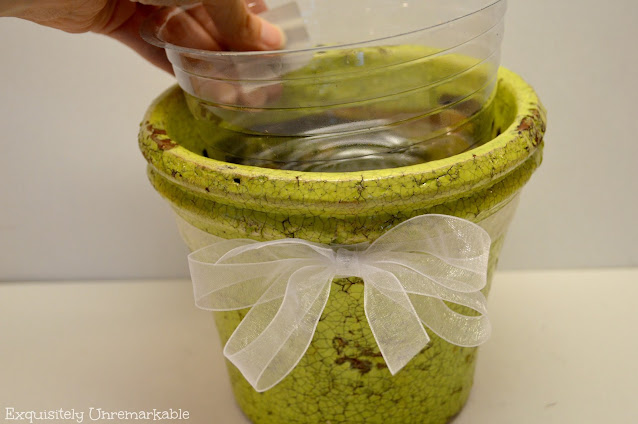 Placing a plastic liner into a green flower pot