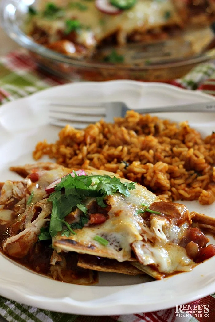 Easy Mexican Chilaquiles by Renee's Kitchen Adventures on a white plate with a fork and Mexican rice