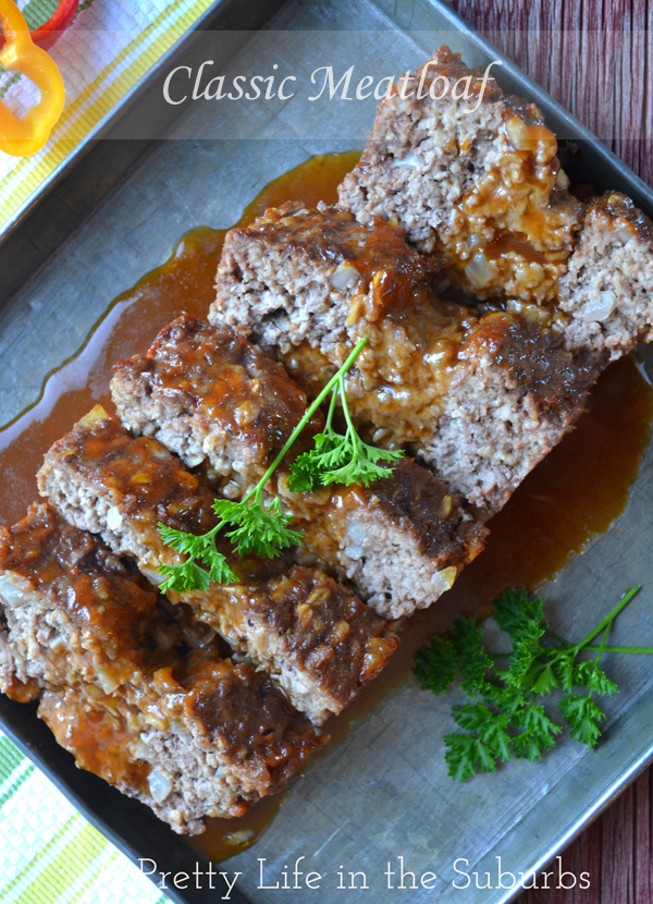 a meatloaf cut into slices on a plate. it is garnished with sauce and fresh parsley