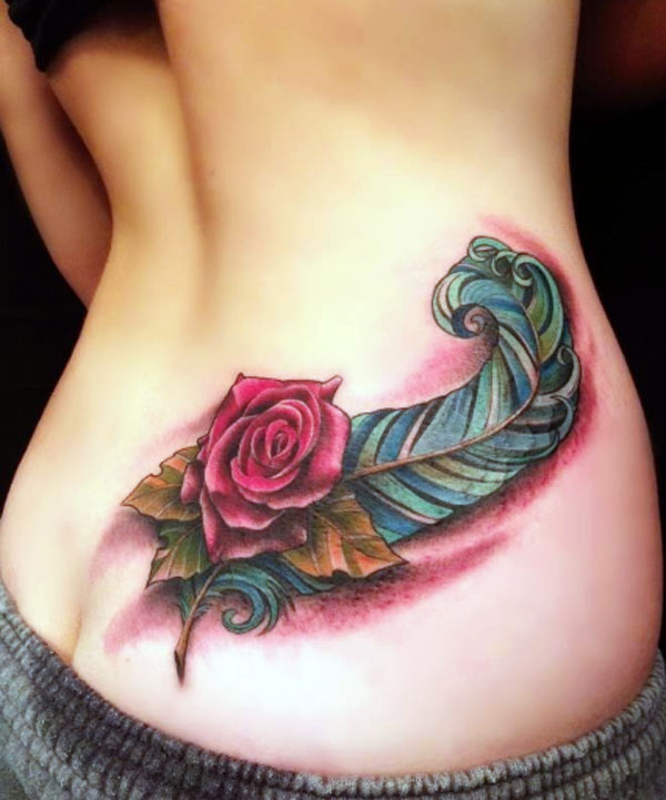 The tattoo is very attractive and realistic the feather with red rose flower lovely colorful ink work tattoo designs