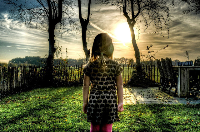 Hermosa imagen de una niña de espaldas contemplando un jardín de juguetes.