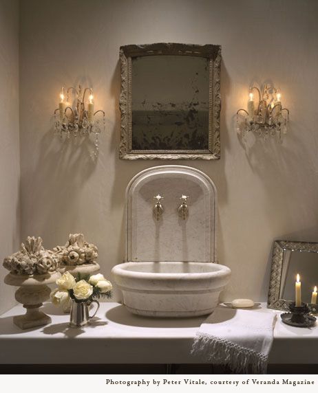 Pamela Pierce designed bathroom with antique stone sink and crystal sconces. #luxuriousbathroom #frenchcountry #oldworldstyle #interiordesign