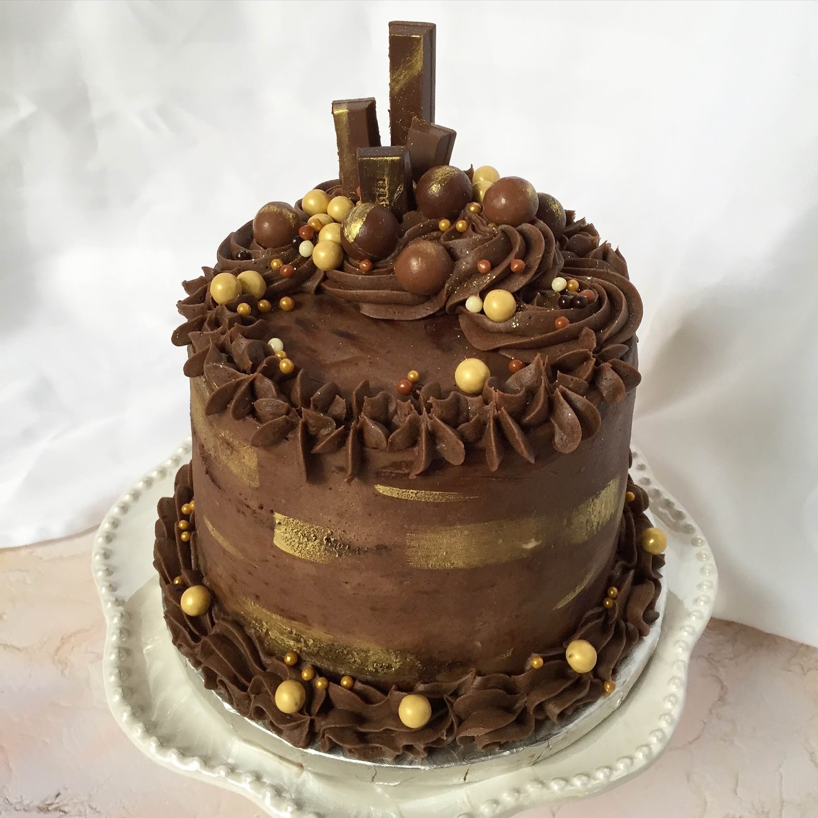 2-tier Wicked Chocolate cake iced in gold ganache decorate…