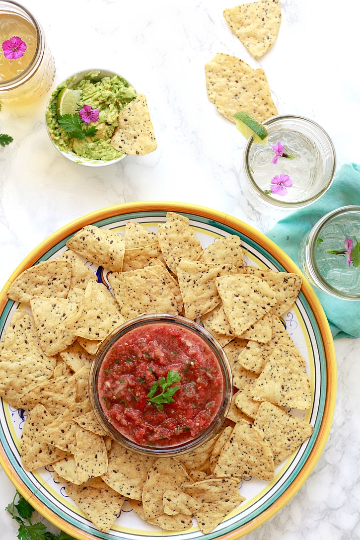 Fresh Tomato Salsa Recipe Beautiful platter of fresh tomato salsa, multigrain chips, and guacamole served with cold drinks.
