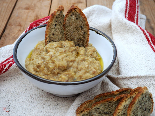 Paté de berenejenas ahumadas, asadas directamente en las brasas y aderezadas con ajo, yogur, azúcar, limón, melaza de granada, zumaque y aceite de oliva.