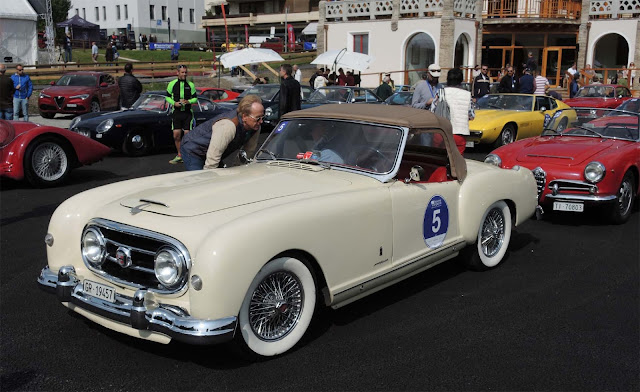 Beiger Nash- Healy Roadster Pininfarina auf der Passione Engadina, Viele Autos auf Parkplatz vor Kulm Country Hotel