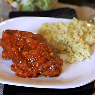 greek cinnamon stewed chicken on a white plate with rice