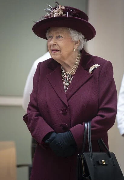 Queen Elizabeth II visited the headquarters of MI5 at Thames House in London. burgundy coat, gold brooch, floral dress