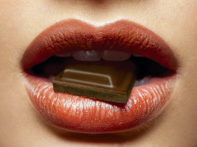 Облизывать шоколад. Помада для губ. Губы шоколадка. Девушка откусывает шоколад. Губы шоколадка.