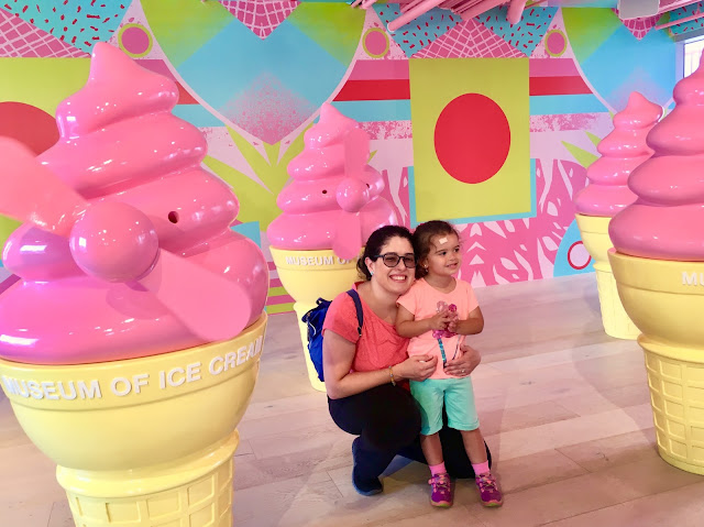 Ice cream in a cone shaped windmills and mother and daughter posing for a photo