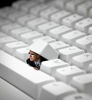 Man peeking out from under keyboard