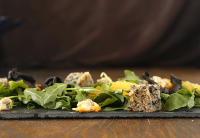 Ensalada con trompetas de la muerte, rúcula, bocados de aceitunas negras