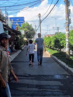 A tourist holds hands with a local Vietnamese man on a walk