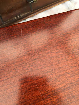 The factory finish is scratched and damaged Damaged finish table surface