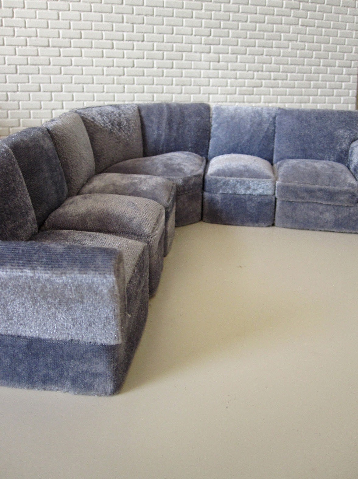 Modern miniature six seater grey velvet corner sofa.