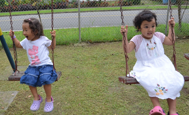 little girls side by side at the swing