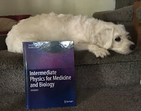 Suki Roth next to the textbook Intermediate Physics for Medicine and Biology.