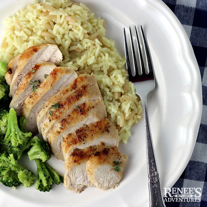 Pan Fried Chicken Breast on plate with fork, rice and broccoli