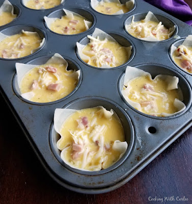 wonton wrappers filled with eggs, cheese and ham in cupcake tin ready to go in oven