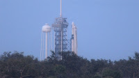Rollout - wytaczanie rakiety Falcon 9 z hangaru na stanowisko startowe na finiszu (po lewej) i po ukończeniu (po prawej), gdzie Dragon 2 znalazł się po raz pierwszy na szczycie Falcona 9 i przy zmodyfikowanej już pod misje załogowe wyrzutni LC-39A. Credits: SpaceflightNow