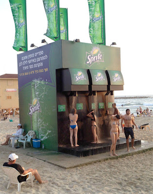 Mujeres en bikini en duchas o regaderas de Sprite en la playa. Mujeres en bikini en duchas o regaderas de Sprite en la playa.