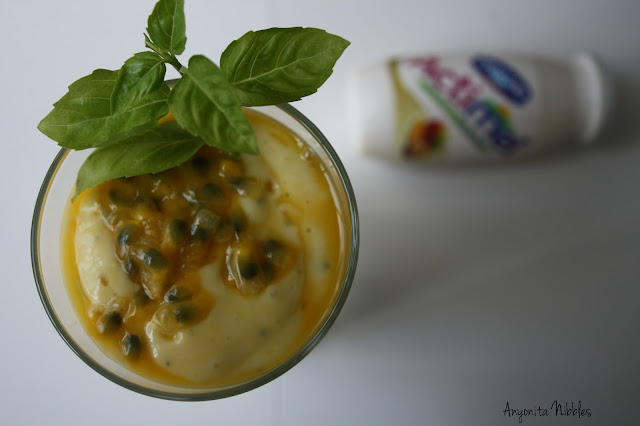Mango and Passion Fruit Smoothie with Frsh Basil and a blurred pot of mango and passion fruit yogurt