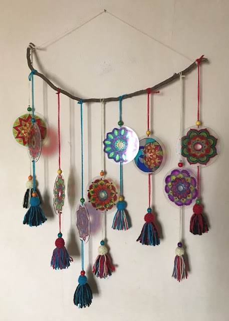 Varios mandalas de muestra pintados sobre CDs Mandalas con adorno de lanas y cuentas de madera