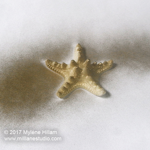 Spray painting the resin starfish with gold spray paint.