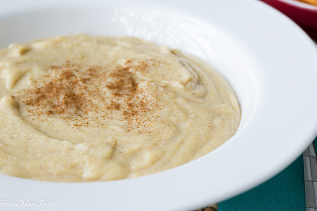 A finished bowl of thick Jamaican cornmeal porridge with nutmeg on top.