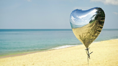 Zilveren ballon op het strand in de zomer.