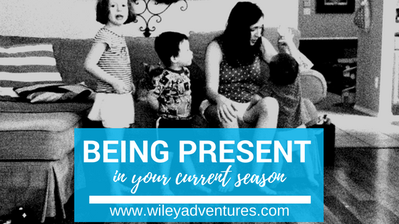 Text: Being Present In Your Current Season www.wileyadventures.com Picture: mom sitting on couch with 3 small children looking at her in black and white