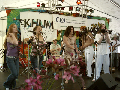 Add caption: (~);-} Musical group "Womama" featuring students from Dr. Novotney's class. Performance at SLAMFEST. Sustainable Living Art Music Festival. Public address system powered by pedaling kids...  Electric Power Generator for bicycle electricity 12 VAC standard automobile battery charging system. photo by Gregory Vanderlaan/ Tour Northern California. Solar Oven CCAT Bart Orlando Samba Parade Humboldt State University Arcata California