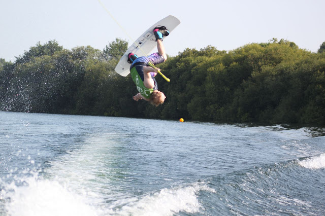 Man performing a wakeboard move in the air upside down