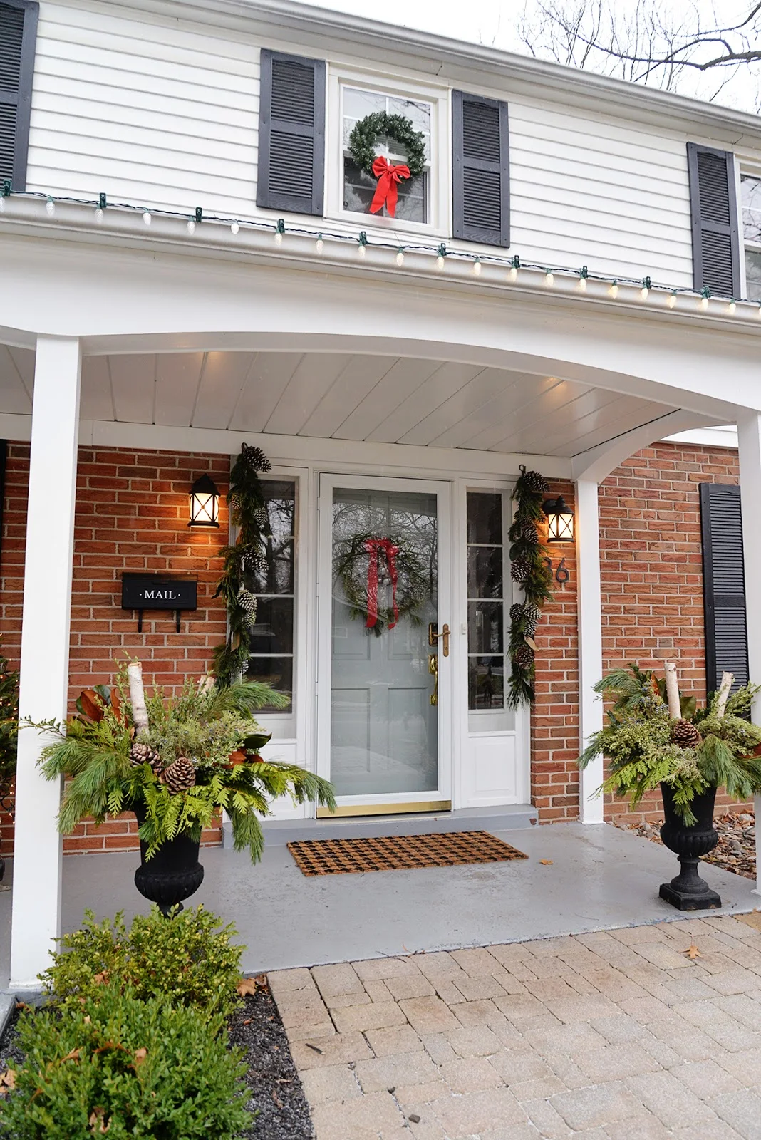 Christmas colonial house with wreaths in windows and DIY outdoor planter
