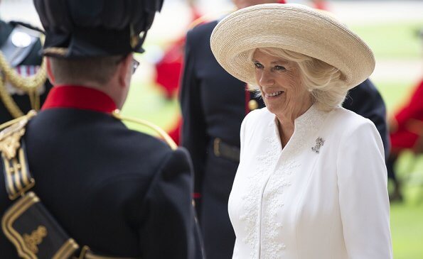 The Duchess of Cornwall wore a white embroidered coat dress with beige leather shoes, and beige hat and she carried beige clutch