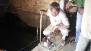 गैस से चाय बनाता व्यक्ति