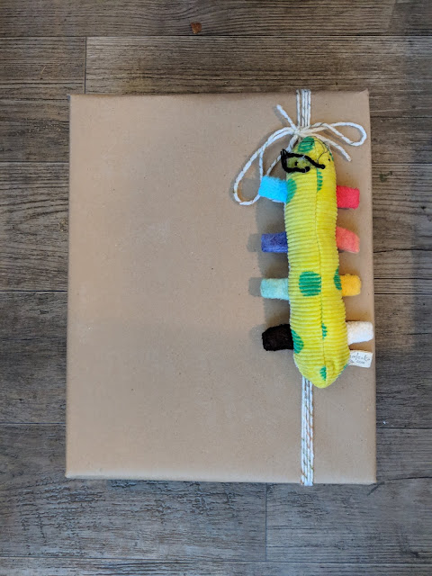 brown paper package for a twelve month old with a caterpillar toy