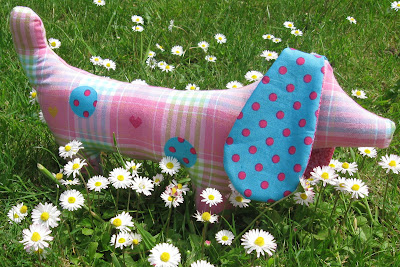 Simple handmade fabric dog in dotty fabrics photographed on grass