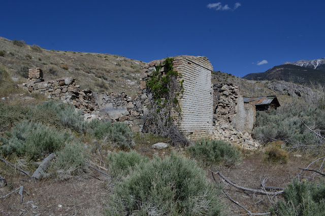 falling rock and stone building beside wooden building