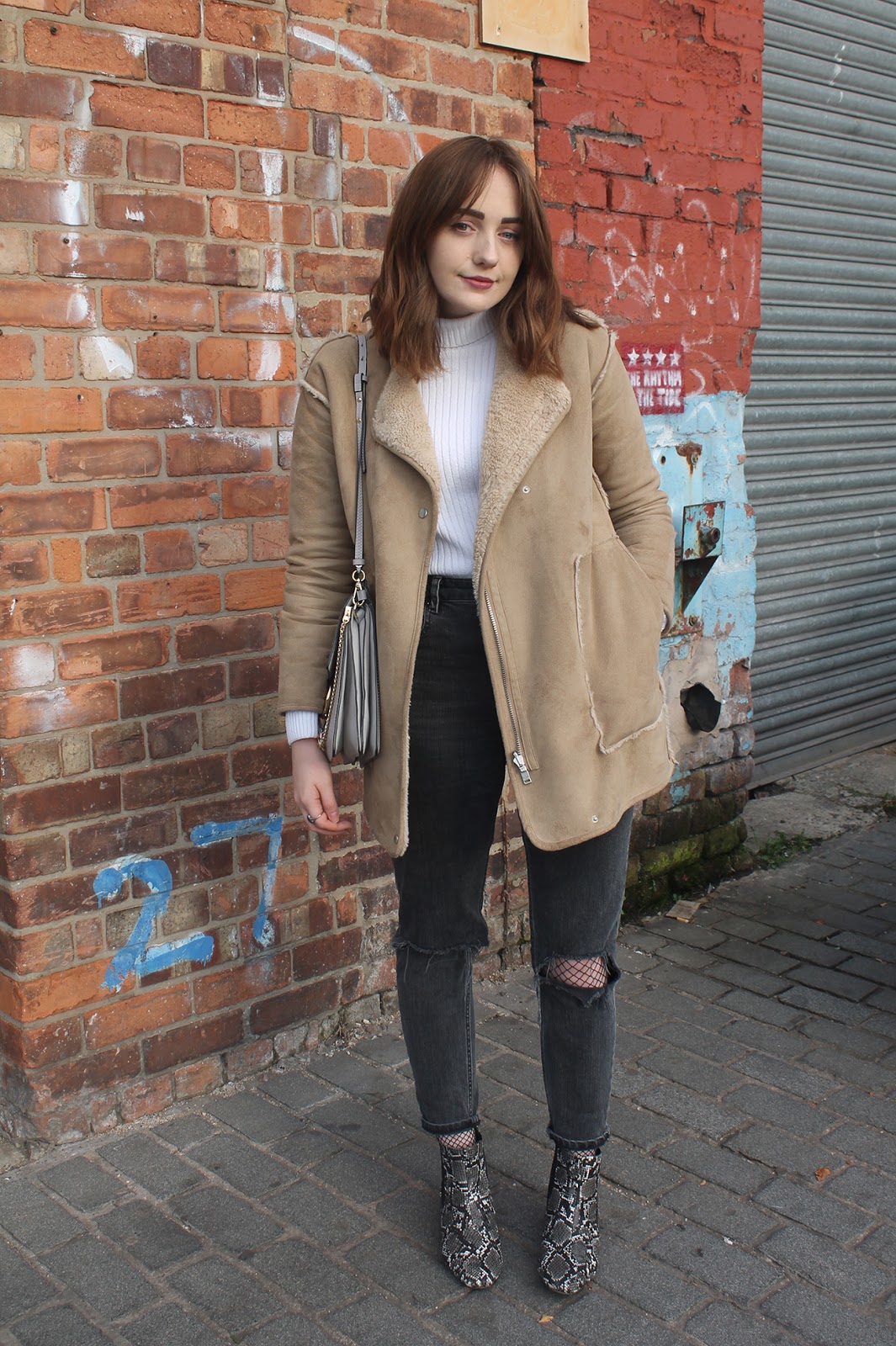 tan faux sheepskin coat from Pull & Bear, white rib roll neck jumper from ASOS, Chloe faye bag in grey copy, ASOS furlough jeans in washed black with busted knees over fishnet tights,  ASOS amber snake boots
