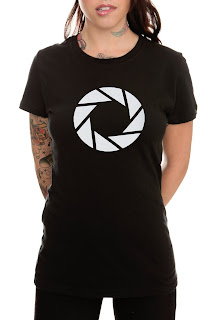 This is a sexy girl with tatoos wearing an Aperture logo T-shirt