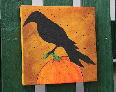 acrylic painting of a crow perched on a pumpkin
