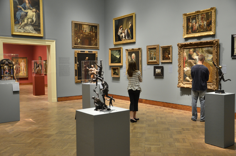 Museum visitors study Renaissance paintings