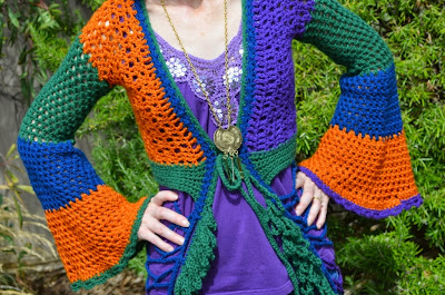Crocheted mesh duster coat in blue, orange, green and purple with bell sleeves and loopy fringe along the edges.