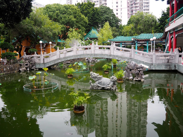 Bridge and statues on the pond in the garden of Sik Sik Yuen Wong Tai Sin Temple, Hong Kong